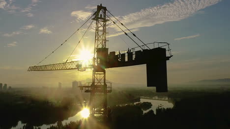 Construction-Work-On-The-Tower-Crane-Machine-To-Built-Tall-Tower-Property-Building-Workplace-Day-And-Clouds-Flowing-Over-City,-The-Mountains-In-Sunset