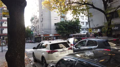 Paisaje-Otoñal-En-La-Avenida-Rivadavia,-Hito-Del-Barrio-De-Flores,-La-Gente-Camina-Por-Las-Calles-De-La-Capital-Argentina-De-Buenos-Aires