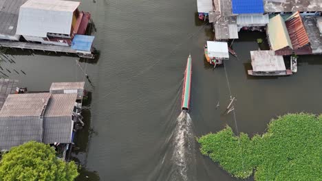 Drone-shot-top-down-on-a-longtail-boat-and-small-neighborhood-outside-of-Pak-Kret-Nonthaburi-Thailand-near-Bangkok