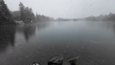 Schnee-Fällt-Auf-Einen-Mystischen-See-In-Österreich,-Umgeben-Von-Bäumen