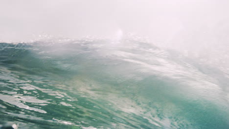 Strong-ocean-wave-glistens-green-as-spray-spits-out-with-beautiful-water-texture