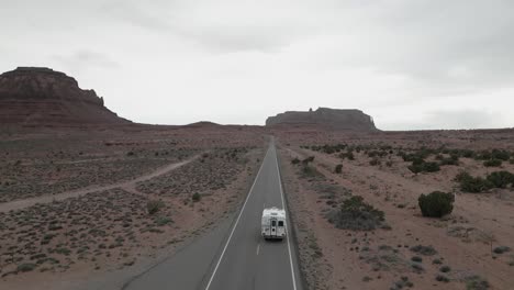 Verfolgung-Der-Luftaufnahme-Eines-Wohnmobils-Auf-Einer-Wüstenstraße-Im-Monument-Valley-Park,-Utah,-USA,-Die-Die-Essenz-Des-Van-Lebens,-Des-Reisens-Und-Der-Erkundung-Einfängt