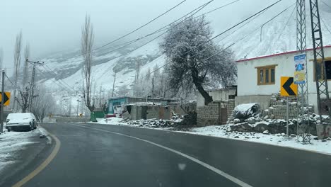 Point-of-View-Aufnahme-Eines-Autos,-Das-Bei-Schneefall-Auf-Den-Straßen-Der-Stadt-Skardy,-Pakistan,-Fährt