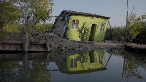 Ein-Armseliges-Kleines-Gewächshaus-Steht-Kaum-Hoch-Am-Fluss