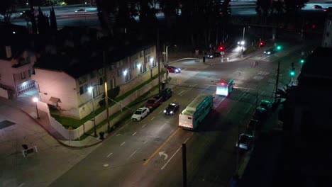 City-Transit-Buses-drive-down-road-at-night