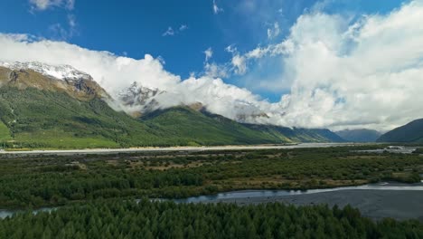 Panoramic-aerial-above-Dart-River-with-cloudy-mountains-in-backdrop-in-Glenorchy