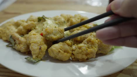 Close-up-shot-chopsticks-grab-Singapore-Salted-Egg-Yolk-Chicken-restaurant-dish-served