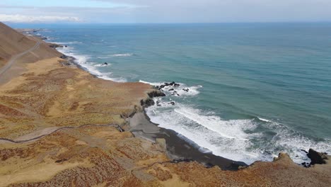 Panoramic-beach-Icelandic-landscape-with-a-road-through-sand-dunes-aerial-ocean