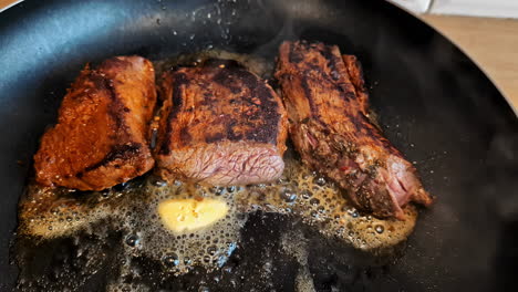 Frying-beef-steak-in-a-skillet-with-butter---sizzling-on-the-stovetop