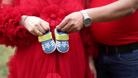 Paar-Posiert-Für-Schwangerschafts-Fotoshooting-Mit-Babyschuhen