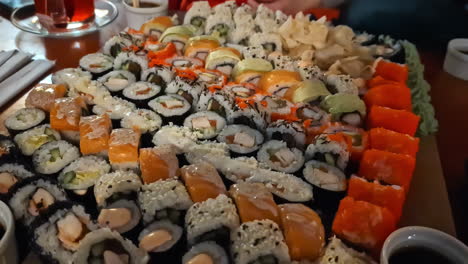 Plato-Con-Muchos-Sushi-Variados-En-La-Fecha-De-La-Cena,-Toma-De-Zoom-Manual