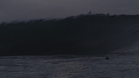 Una-Gran-Ola-Perfecta-Rompe-Entre-Los-Surfistas-Al-Atardecer-En-Cámara-Lenta