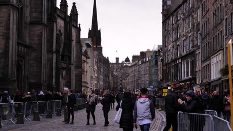 People-walking-along-the-Royal-Mile-looking-towards-Edinburgh-Castle-in-winter,-Scotland