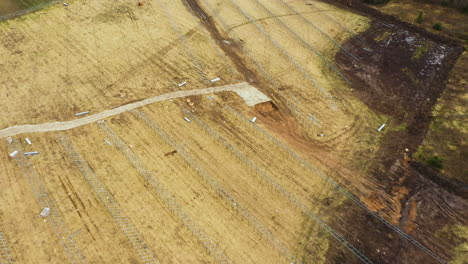 Luftaufnahme-Einer-Unvollendeten-Solarpanel-Farm-Auf-Einem-Großen-Acker-In-Der-Natur