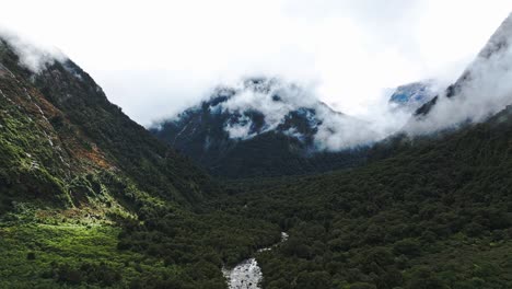 Dolly-Panorámica-Aérea-Establece-El-Valle-Del-Río-Milford-Sound-Con-Impresionantes-Nubes