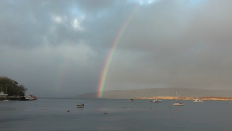 Tilting-shot-revealing-a-double-rainbow-over-the-bay-of-Tobermory-with-boats