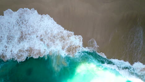 Big-waves-of-tropical-emerald-colored-sea-breaking-on-sandy-beach