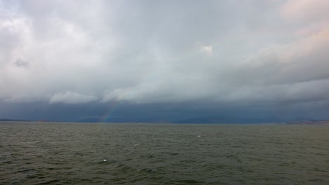 Hand-held-shot-of-a-rainbow-over-the-ocean-from-a-ferry-sailing-to-the-Isle-of-Mull