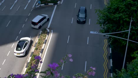 Zeitlupen-Landschaftsansicht-Von-Autos,-Die-An-Der-Kreuzung-Einer-Stark-Befahrenen-Autobahn-Auf-Einer-Straße-In-Der-Innenstadt-Von-Singapur,-CBD,-Asien,-Abbiegen