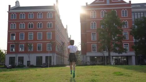 Beautiful-Teenage-Girl-Students-Run-Towards-The-School-Building,-Schoolgirl-Is-Late-Against-Blue-Sky-And-Sun