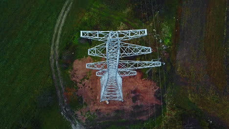 Aerial-view-tilting-backwards-over-a-newly-installed-electric-pylon,-gloomy,-fall-day