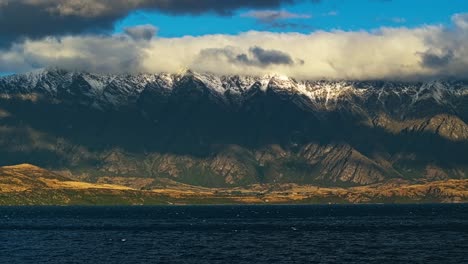 Mehrschichtige-Berglandschaft,-Die-Von-Wolken-über-Dem-Himmel-Zu-Schnee-Und-Wald-über-Dem-Lake-Wakatipu-Abfällt