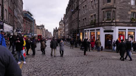 People-walking-along-the-Royal-Mile-looking-away-from-Edinburgh-Castle-in-winter,-Scotland