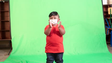 general-shot-of-deaf-boy-with-mask-with-green-background
