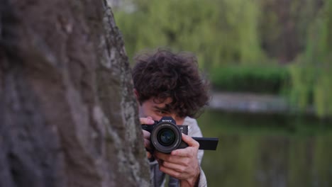 El-Detective-Paparazzi-Se-Esconde-Detrás-Del-Tronco-De-Un-árbol-Y-Usa-Una-Cámara-Digital-Para-Tomar-Fotos.