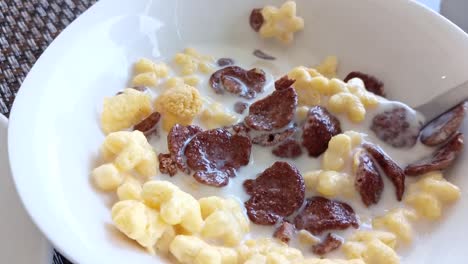 Slow-motion-of-stirring-cereal-in-a-bowl-of-milk-for-breakfast