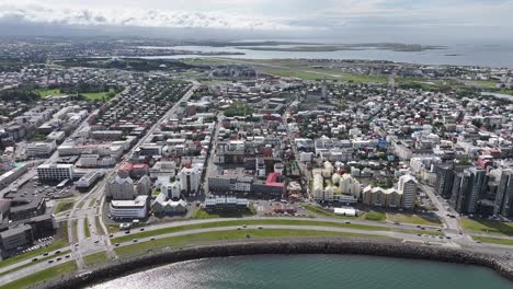 Aerial-View-of-Reykjavik-City-Center,-Iceland,-Coastal-Traffic,-Downtown-Buildings-and-Church,-Drone-Shot-60fps
