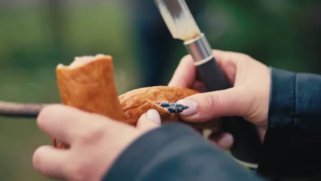 Eine-Frau-Stopft-Eine-Wurst-Auf-Einen-Spieß