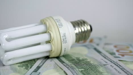 Light-bulb-rotate-on-100-usd-note-bills-Increase-in-electricity-tariffs