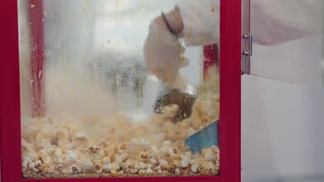 Popped-kernels-burst-in-a-red-popcorn-machine,-a-blur-of-snack-time-excitement