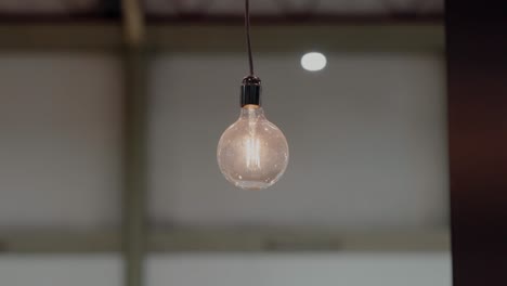 Single-glowing-lightbulb-suspended-in-space,-a-symbol-of-bright-ideas-and-classic-design