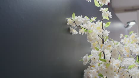 Elegante-Künstliche-Kirschblütenzweige-Vor-Einem-Weichgezeichneten-Hintergrund,-Perfekt-Für-Ruhige-Innendekorationsszenen