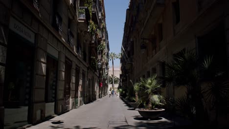 Barcelona-street-scene-with-shadows,-sunny-day,-pedestrians-in-distance,-European-architecture
