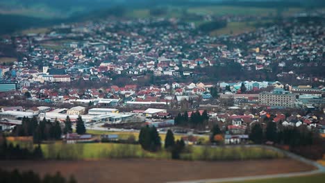 Miniaturized-aerial-view-of-a-small-town-in-rural-Germany-and-a-surrounding-landscape