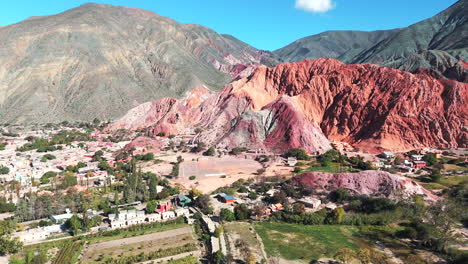 Drone-Dando-Vueltas-Alrededor-De-Purmamarca,-Mostrando-Su-Montaña-De-Siete-Colores-Y-Su-Pintoresco-Pueblo.