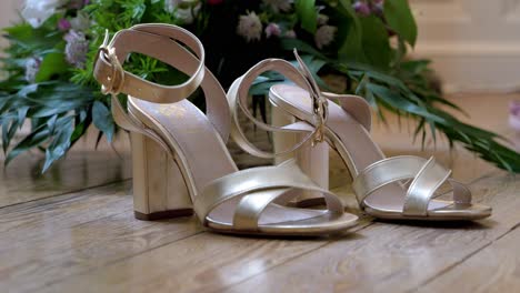 Slow-establishing-shot-of-the-brides-wedding-shoes-infront-of-a-bunch-of-flowers
