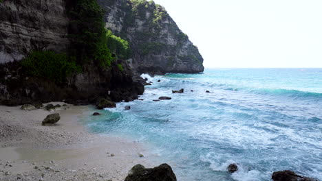 Im-Schatten-Der-Felsen,-Balinesische-Fischer-Am-Ufer-Versuchen,-Nahrung-Zu-Fangen
