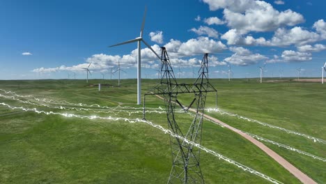 Electricity-flowing-through-power-lines-at-wind-farm-in-rural-USA-during-summer