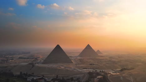 Aerial-of-sunset-view-over-the-Great-Pyramids-of-Giza,-on-the-Pyramids-Plateau-in-Egypt,-embodies-the-concept-of-timeless-grandeur-and-majesty