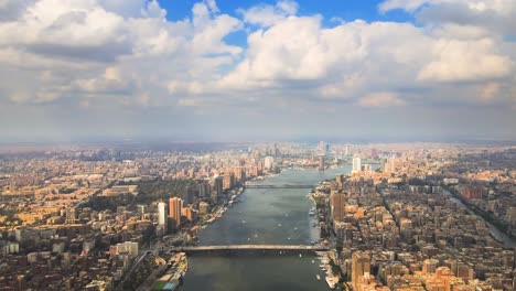 Aerial-of-the-Nile-River-meanders-through-Cairo-city,-with-a-drone-gliding-past-the-beauty-of-Cairo,-Egypt,-embodying-the-concept-of-urban-vitality-and-architectural-marvels