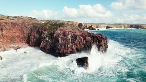 Luftaufnahme-Einer-4K-Drohne-Mit-Rückansicht-Der-Großen,-Brechenden-Wellen-An-Der-Versteckten-Steilküste-Praia-Da-Zimbreirinha-In-Der-Nähe-Von-Bordeira-In-Der-Algarve-Region-Von-Portugal