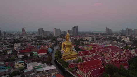 Aerial-drone-rotating-shot-over-Wat-Paknam-Bhasicharoen-tapınağı-içindeki-Big-Buda-alongside-Chao-Phraya-river-canal-during-evening-time