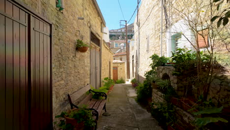 Un-Callejón-De-Piedra-Tradicional-En-Lefkara-Bordeado-De-Macetas-Y-Bancos,-Que-Invita-A-Un-Paseo-Tranquilo-Por-El-Pueblo