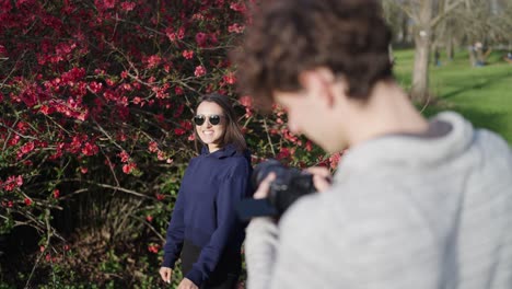 Creative-photographer-and-female-model-team-near-blooming-Chinese-Quince-shrub