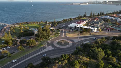 Aerial-establishing-shot-of-roundabout-at-coastline-in-Esperance-Town-during-golden-sunset,-Western-Australia