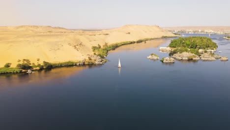 Aerial-of-the-Nile-River-,-traditional-Egyptian-sailing-boats,-in-Aswan,-Egypt,-embodying-the-concept-of-timeless-maritime-heritage-and-cultural-richness